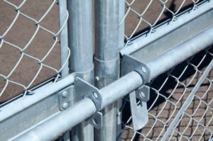 ステンレス製の菱形金網フェンスと支柱、ゲート金具の接合部。丈夫な構造が特徴。