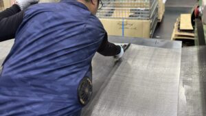 平織金網を切断している作業風景