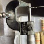 超極細ドリルをデジタルのマイクロメーターで測定している様子。測定値は0.138mmを示している。